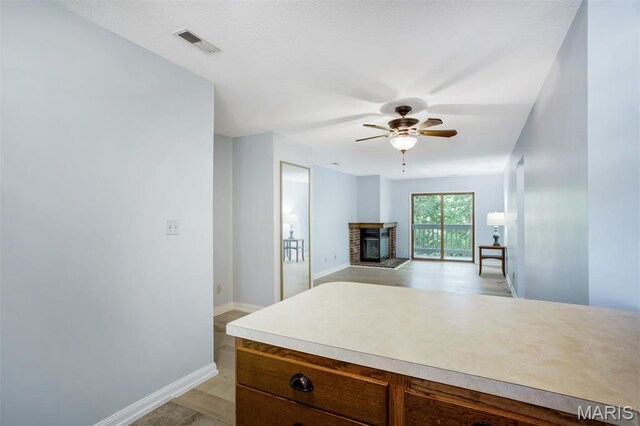 12975 Bryce Canyon Dr Unit D, Maryland Heights, MO 63043 - kitchen with a fireplace, ceiling fan, and light countertops