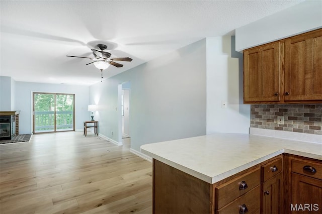 12975 Bryce Canyon Dr Unit D, Maryland Heights, MO 63043 - kitchen with a ceiling fan, brown cabinetry, light countertops, and backsplash
