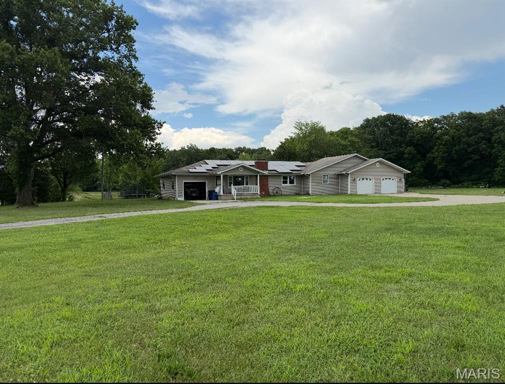 3612 Rte 4, Staunton, IL 62088 - view of front facade featuring roof mounted solar panels, driveway, an attached garage, and a front yard