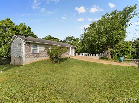 4213 Flucom Rd, De Soto, MO 63020 - rear view of house featuring an attached garage and brick siding