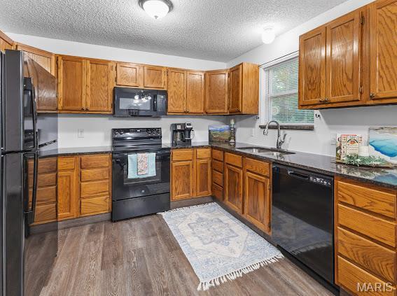 4213 Flucom Rd, De Soto, MO 63020 - kitchen featuring black appliances, a textured ceiling, dark wood-style floors, and brown cabinets