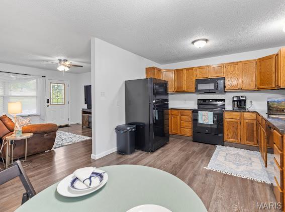 4213 Flucom Rd, De Soto, MO 63020 - kitchen featuring black appliances, brown cabinetry, wood finished floors, ceiling fan, and a textured ceiling