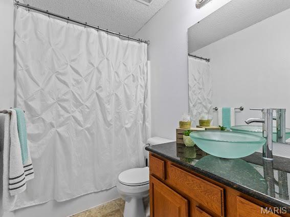 4213 Flucom Rd, De Soto, MO 63020 - bathroom with a textured ceiling, vanity, and shower / bath combo with shower curtain
