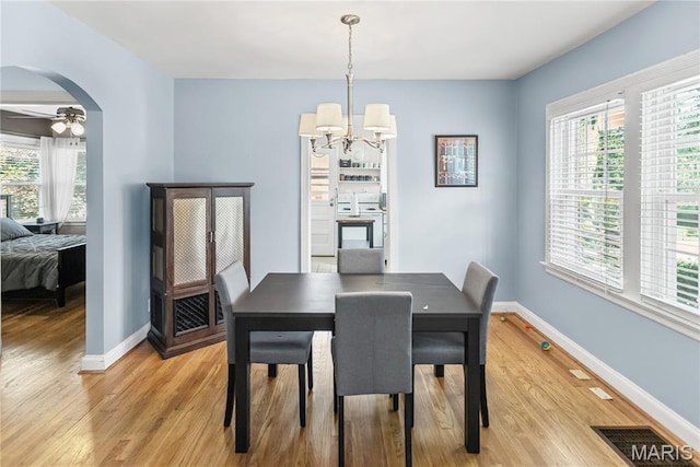 1106 Danforth St, Alton, IL 62002 - dining room with light wood-style floors, a chandelier, a ceiling fan, and arched walkways