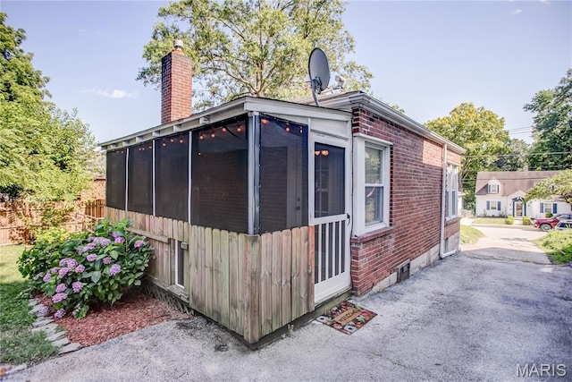 1106 Danforth St, Alton, IL 62002 - view of home's exterior featuring brick siding, a sunroom, and a chimney