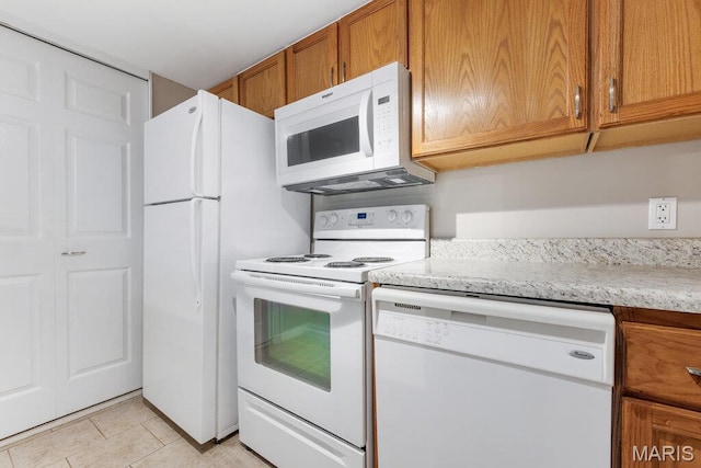 4 Fairways Cir Unit I, Saint Charles, MO 63303 - kitchen with white appliances, brown cabinetry, and light tile patterned floors