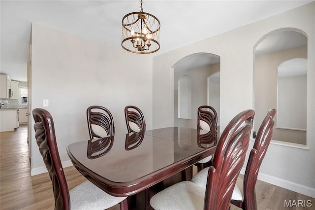 904 Ampere Pl, Lake St Louis, MO 63367 - dining room featuring light wood-type flooring, arched walkways, and a chandelier