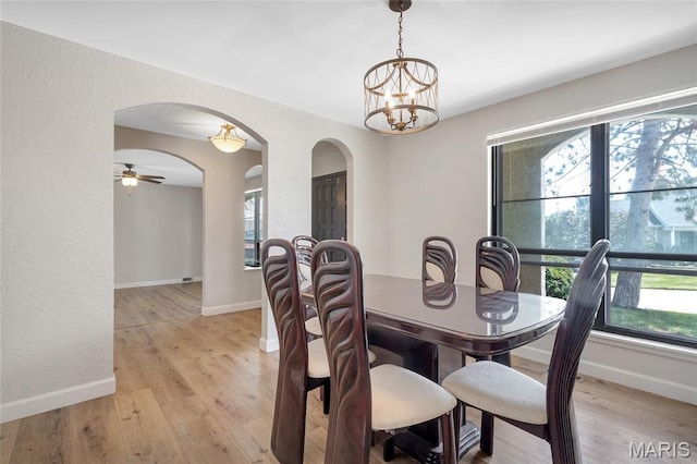 904 Ampere Pl, Lake St Louis, MO 63367 - dining room with arched walkways, light wood-type flooring, a textured wall, and a chandelier