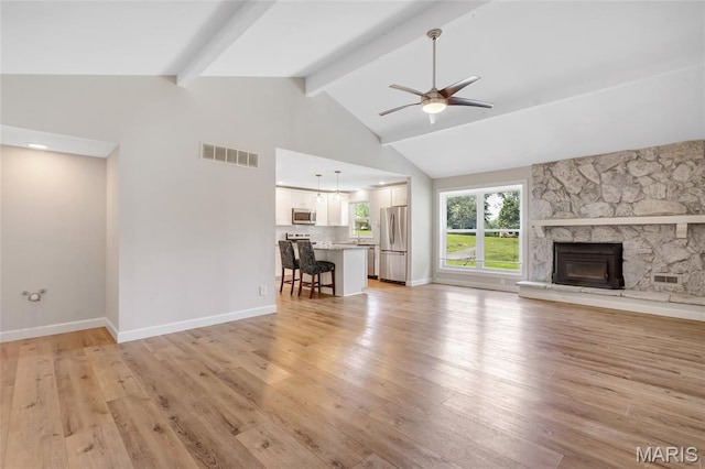 904 Ampere Pl, Lake St Louis, MO 63367 - unfurnished living room featuring a ceiling fan, beam ceiling, a stone fireplace, light wood-type flooring, and high vaulted ceiling