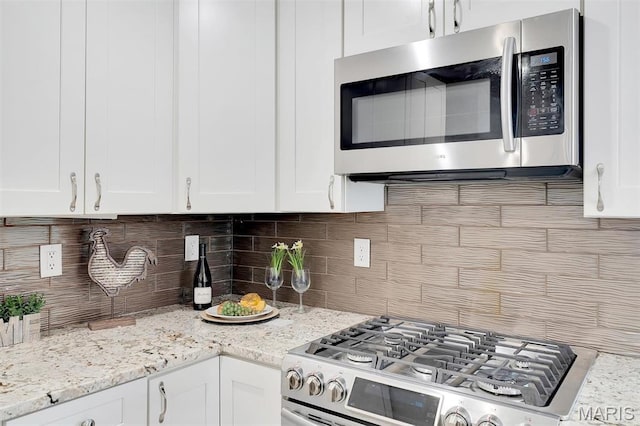 3253 Walter Ave, Maplewood, MO 63143 - kitchen featuring appliances with stainless steel finishes, decorative backsplash, and white cabinets