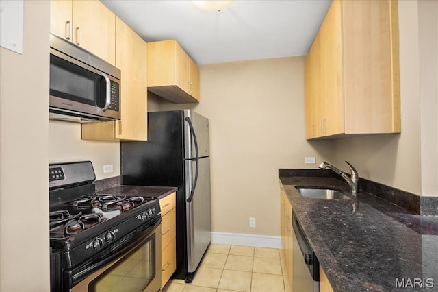210 N 17th St Unit 1005, Saint Louis, MO 63103 - kitchen with appliances with stainless steel finishes, light brown cabinetry, light tile patterned floors, and dark stone counters