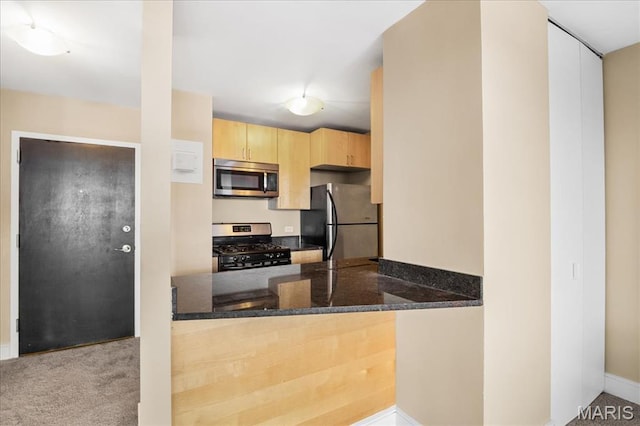 210 N 17th St Unit 1005, Saint Louis, MO 63103 - kitchen with appliances with stainless steel finishes, light brown cabinets, dark stone countertops, and a peninsula