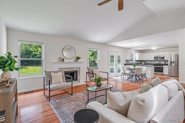 3848 Bedford Pointe Dr, Wentzville, MO 63385 - living room featuring healthy amount of natural light, lofted ceiling, a high end fireplace, ceiling fan, and light wood-type flooring