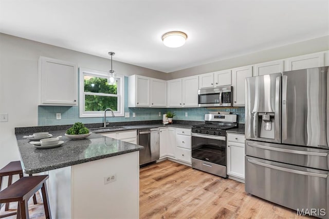 3848 Bedford Pointe Dr, Wentzville, MO 63385 - kitchen featuring stainless steel appliances, a peninsula, white cabinetry, and decorative backsplash