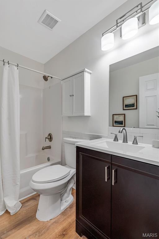 3848 Bedford Pointe Dr, Wentzville, MO 63385 - full bath featuring vanity, wood finished floors, and shower / tub combo with curtain
