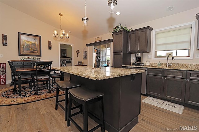3576 Mill View Xing, Cape Girardeau, MO 63701 - kitchen with light wood-style flooring, vaulted ceiling, a center island, light stone countertops, and a breakfast bar