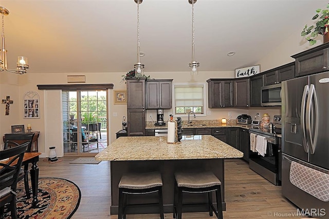 3576 Mill View Xing, Cape Girardeau, MO 63701 - kitchen with appliances with stainless steel finishes, light wood-type flooring, a chandelier, and light stone countertops