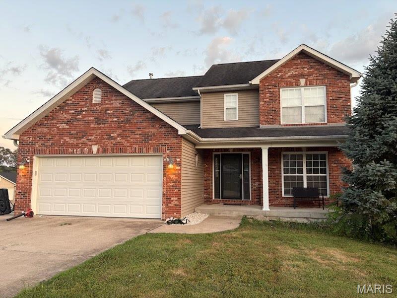 168 Juliana Ct, Columbia, IL 62236 - traditional-style house featuring brick siding, driveway, a porch, a garage, and a front yard