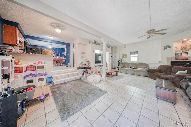 110 S Oak St, Rolla, MO 65401 - living room featuring ceiling fan, a textured ceiling, light tile patterned floors, and a tile fireplace