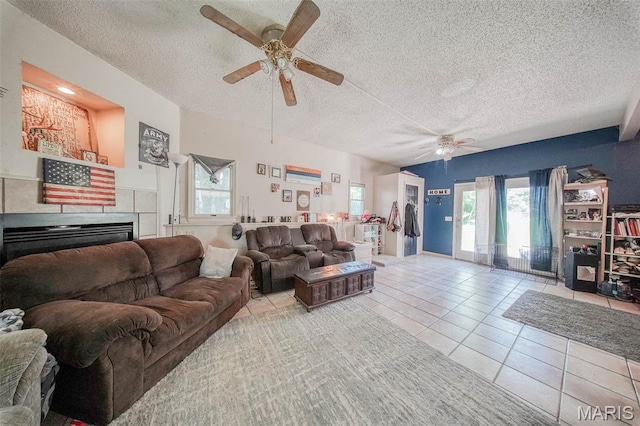 110 S Oak St, Rolla, MO 65401 - tiled living room featuring a ceiling fan, a textured ceiling, plenty of natural light, and a fireplace