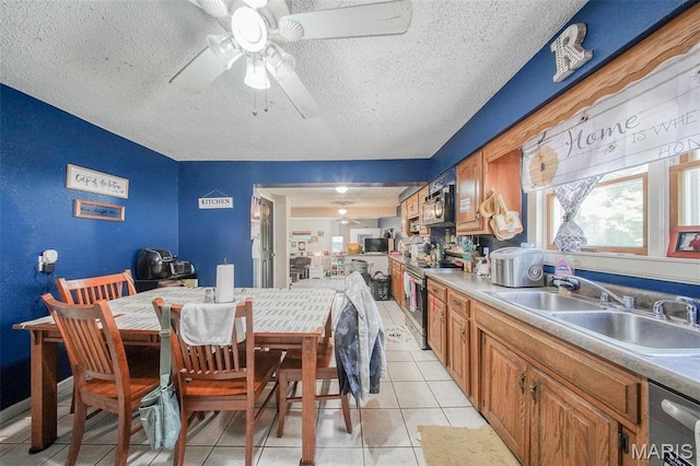 110 S Oak St, Rolla, MO 65401 - kitchen featuring appliances with stainless steel finishes, a textured ceiling, light tile patterned floors, ceiling fan, and brown cabinetry