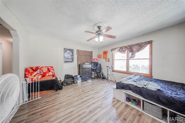 110 S Oak St, Rolla, MO 65401 - bedroom with arched walkways, wood finished floors, a textured ceiling, and ceiling fan