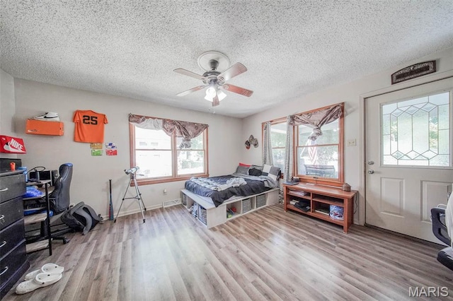 110 S Oak St, Rolla, MO 65401 - bedroom with wood finished floors, a textured ceiling, a ceiling fan, and an office area