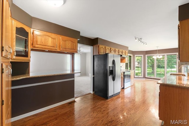 15693 Dresden Lake Ct, Chesterfield, MO 63017 - kitchen with stainless steel fridge with ice dispenser, range, track lighting, stone countertops, and wood finished floors