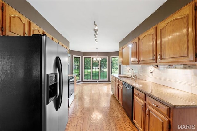 15693 Dresden Lake Ct, Chesterfield, MO 63017 - kitchen with black appliances, light wood-type flooring, a chandelier, backsplash, and brown cabinetry
