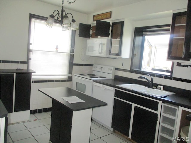 2823 Darwin Ct, Saint Louis, MO 63121 - kitchen with white appliances, dark countertops, a chandelier, light tile patterned floors, and a kitchen island