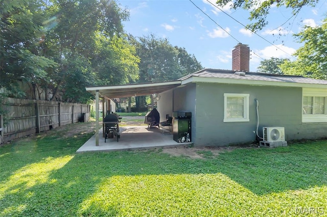 503 Emerson St, Kennett, MO 63857 - back of house featuring a chimney, an attached carport, concrete block siding, and a patio
