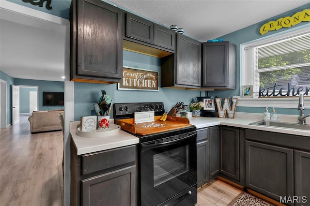 503 Emerson St, Kennett, MO 63857 - kitchen with black electric range, light wood-type flooring, and light countertops
