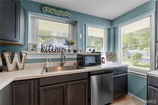 503 Emerson St, Kennett, MO 63857 - kitchen with dishwasher, black microwave, a textured wall, light countertops, and dark brown cabinetry