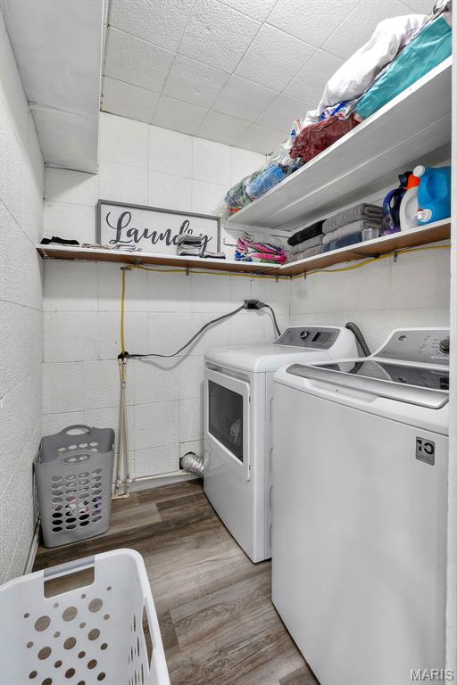 503 Emerson St, Kennett, MO 63857 - washroom with separate washer and dryer, wood finished floors, and concrete block wall