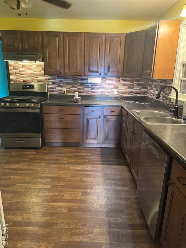 7 N Leota St Unit 7, Dexter, MO 63841 - kitchen with stainless steel appliances, under cabinet range hood, dark wood-style floors, backsplash, and dark countertops