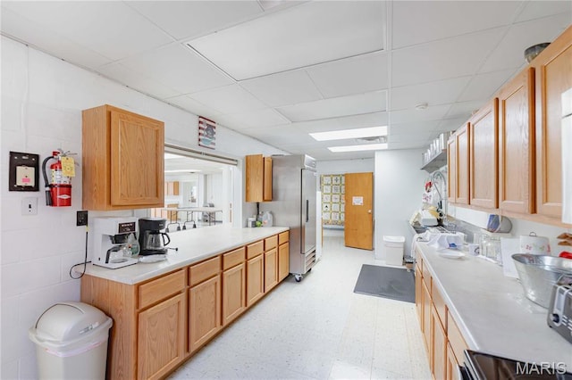 4869 Scottsdale Rd, House Springs, MO 63051 - kitchen featuring light countertops, light floors, a paneled ceiling, and freestanding refrigerator