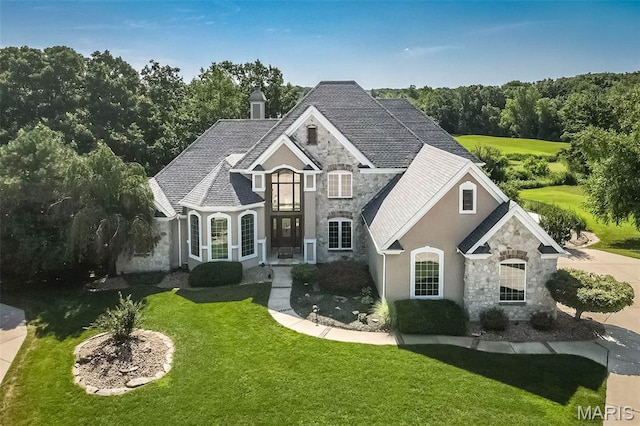 2314 Longest Dr, Wentzville, MO 63385 - french country style house featuring stone siding, a front yard, and stucco siding