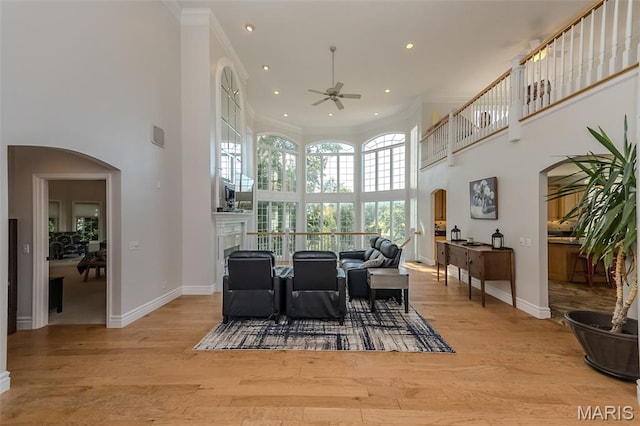 2314 Longest Dr, Wentzville, MO 63385 - dining space featuring arched walkways, ceiling fan, a towering ceiling, light wood-type flooring, and crown molding