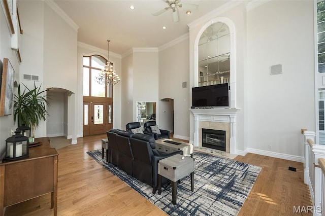 2314 Longest Dr, Wentzville, MO 63385 - living area featuring light wood-style floors, ceiling fan, arched walkways, crown molding, and a high ceiling