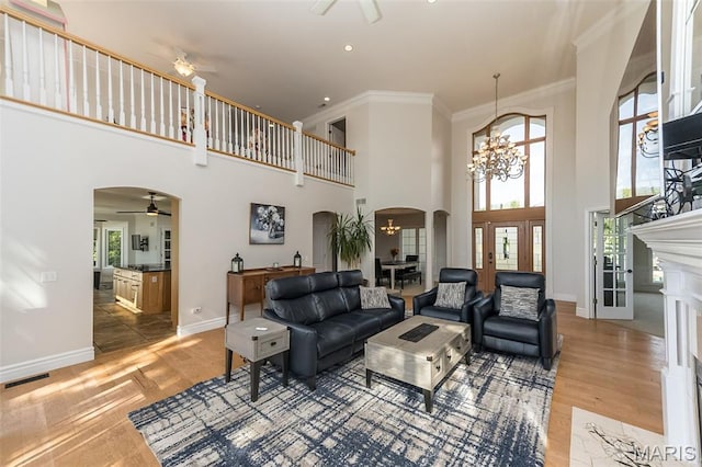 2314 Longest Dr, Wentzville, MO 63385 - living room featuring arched walkways, ceiling fan, a high ceiling, light wood finished floors, and ornamental molding
