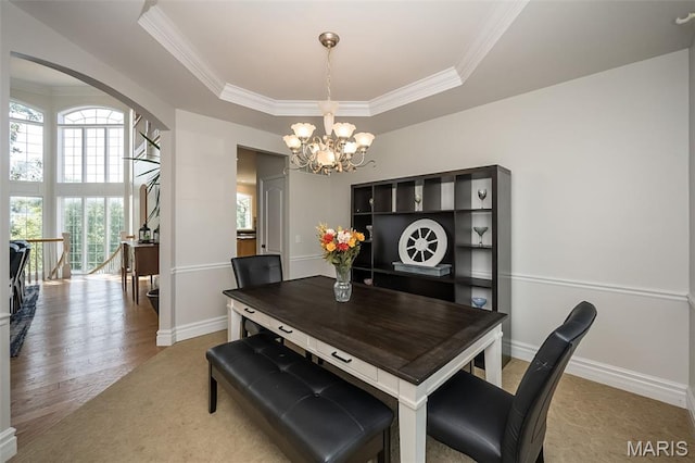 2314 Longest Dr, Wentzville, MO 63385 - dining space with a raised ceiling, a chandelier, ornamental molding, arched walkways, and wood finished floors