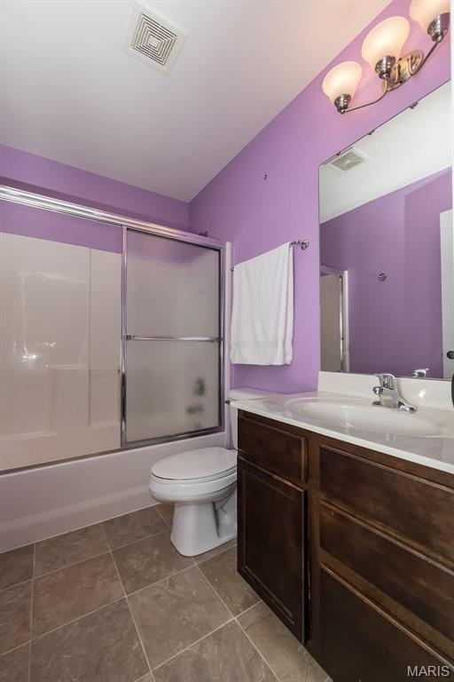 2314 Longest Dr, Wentzville, MO 63385 - bathroom featuring vanity, shower / bath combination with glass door, and tile patterned floors