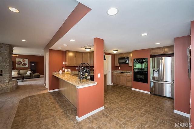 2314 Longest Dr, Wentzville, MO 63385 - kitchen featuring black appliances, brown cabinetry, recessed lighting, open floor plan, and light stone countertops