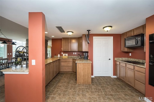 2314 Longest Dr, Wentzville, MO 63385 - kitchen featuring black appliances, light stone counters, and brown cabinetry
