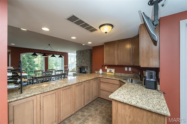 2314 Longest Dr, Wentzville, MO 63385 - kitchen with recessed lighting, light stone counters, a peninsula, and a stone fireplace