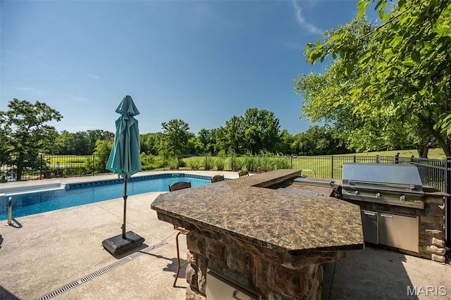 2314 Longest Dr, Wentzville, MO 63385 - view of pool with an outdoor kitchen, a fenced backyard, a patio area, an outdoor bar, and view of scattered trees