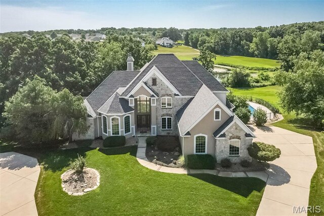 2314 Longest Dr, Wentzville, MO 63385 - french provincial home featuring stone siding, a chimney, a front lawn, a shingled roof, and stucco siding