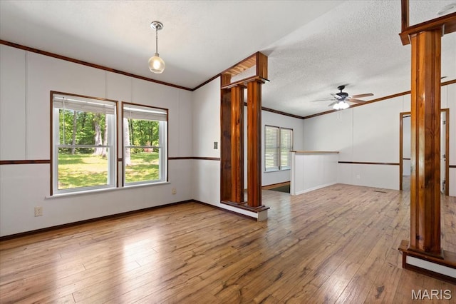 434 Cool Springs Ln, Wright City, MO 63390 - unfurnished room featuring ornamental molding, ornate columns, ceiling fan, hardwood / wood-style flooring, and a textured ceiling