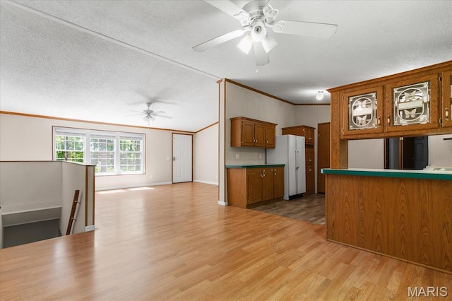 434 Cool Springs Ln, Wright City, MO 63390 - kitchen with brown cabinets, ceiling fan, crown molding, light wood-style floors, and freestanding refrigerator