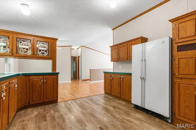 434 Cool Springs Ln, Wright City, MO 63390 - kitchen with freestanding refrigerator, brown cabinets, light wood-style floors, crown molding, and a textured ceiling